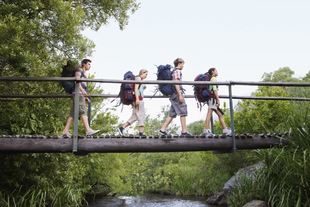 Family Hiking Across Bridge